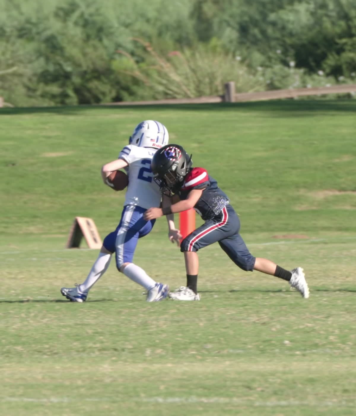 Forces defender tackling the Blue Devils ball carrier in white and blue